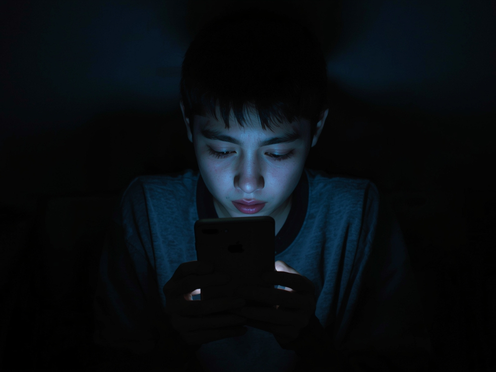 Garoto mexendo no celular com a mente dopaminada